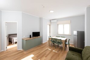 Un apartament modern amb zona de menjador, cuina i saló.