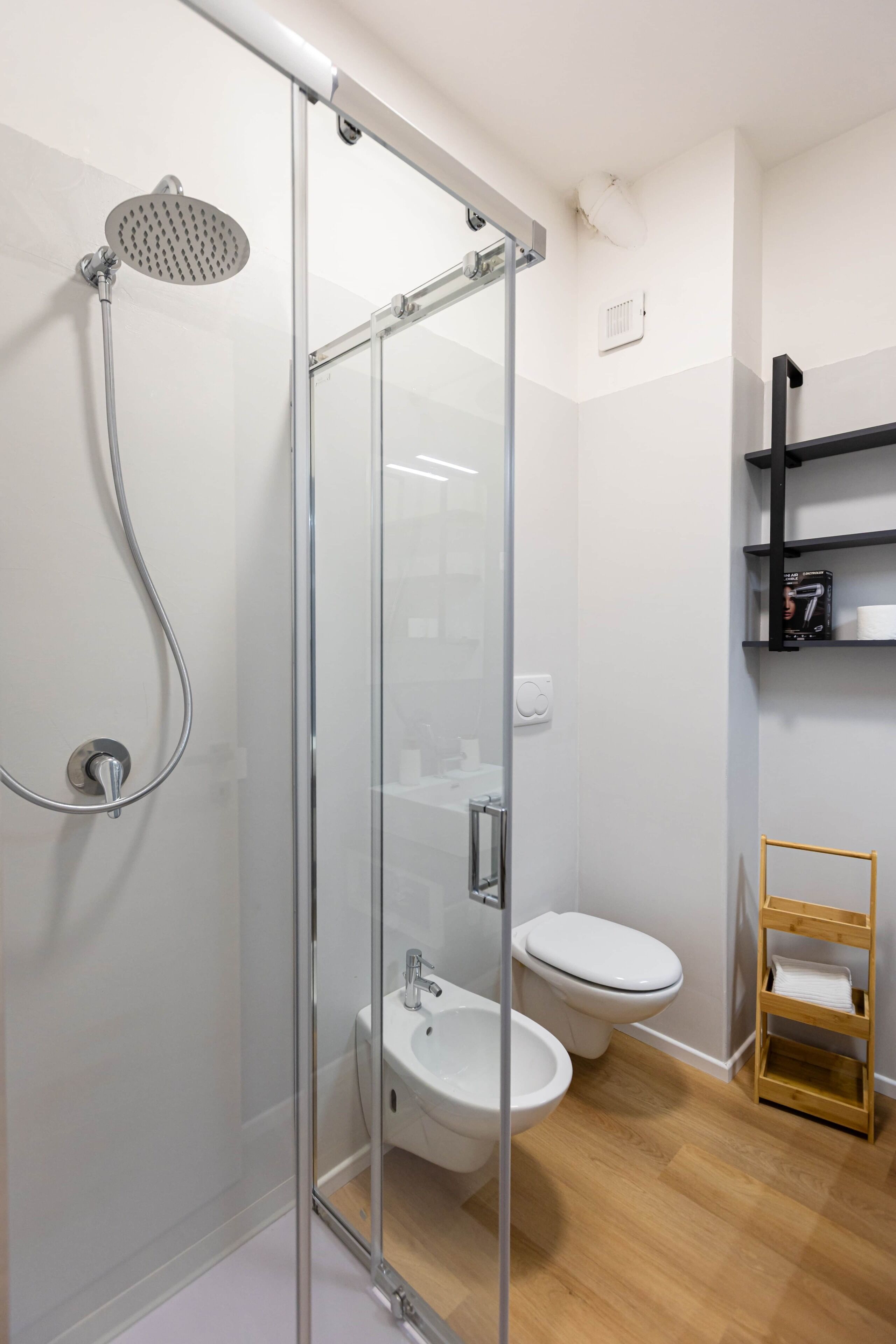 Une salle de bain moderne dotée d’une douche à parois de verre, de toilettes et d’un lavabo.