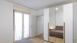 Una camera da letto moderna con un grande specchio, un letto e una porta scorrevole.