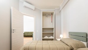 Une chambre à coucher avec un lit, une armoire et une table de chevet.