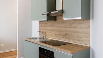 Réfrigérateur, un four, surface de cuisson, vaisselle et ustensiles