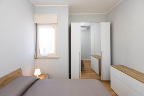 Une chambre à coucher avec un lit, une lampe de chevet et une armoire.
