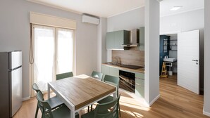 Una cuina compacta amb zona de menjador, nevera i rentapelats.