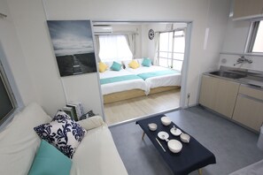 Une pièce de taille modeste comprenant un lit, une petite kitchenette et un coin repas.