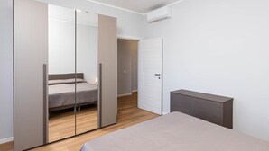Una camera da letto con un letto, un armadio e un comodino.