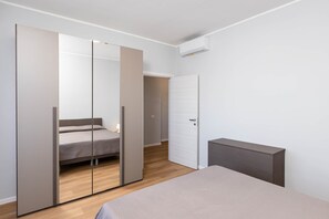 Un dormitorio con cama, armario y mesita de noche.
