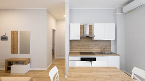 A modern kitchen with white cabinets, a wooden countertop, and a dishwasher. - Sea View Apartment (Margherita di Savoia)