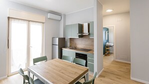 Eine moderne Küche mit Holztisch und -stühlen, einem eingebauten Backofen und einem Spülbecken.