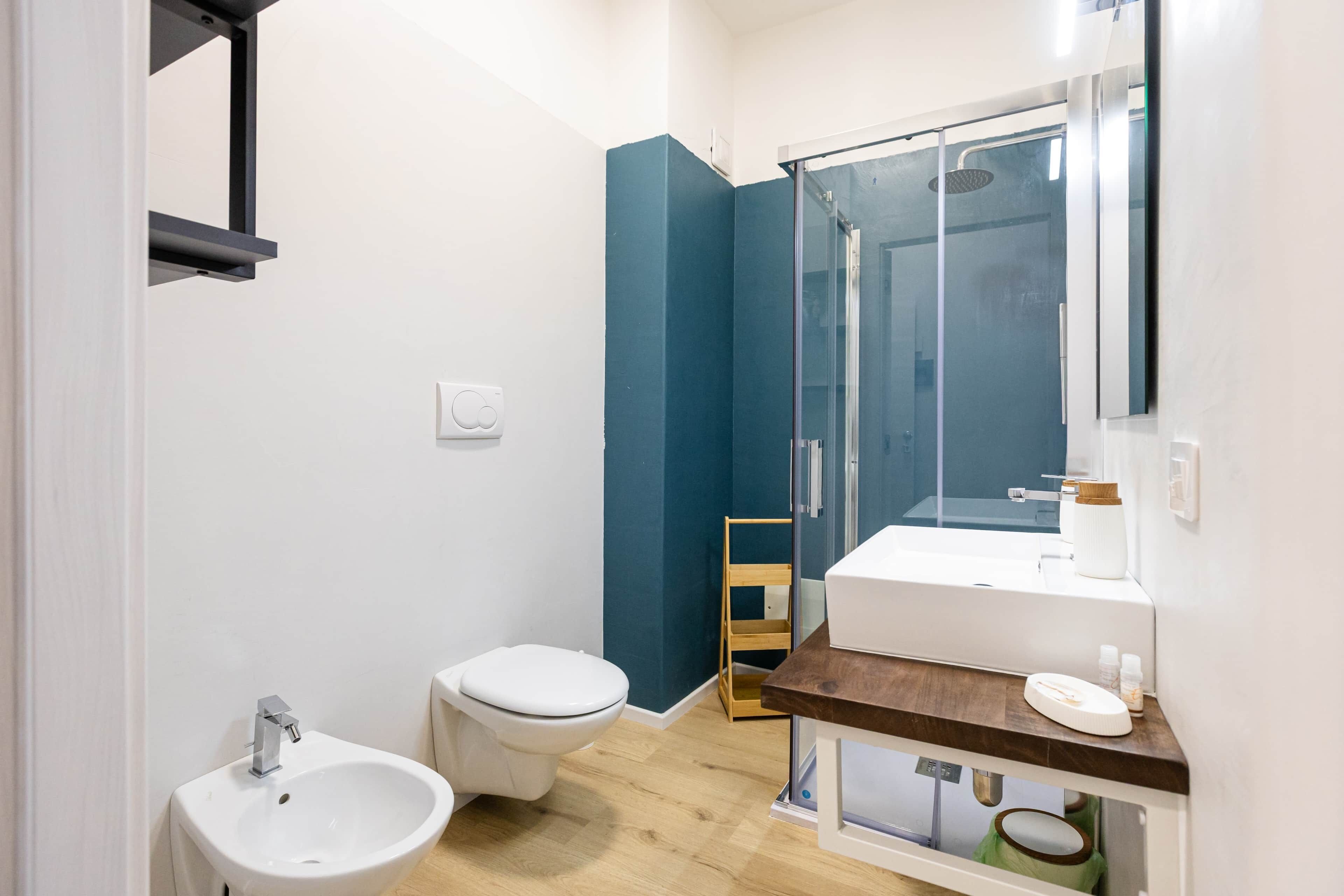 Une salle de bain moderne avec un lavabo blanc, des toilettes blanches et une douche à parois de verre.