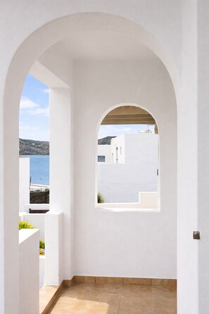 Un arco de entrada que da a un balcón con vistas a un paisaje costero.