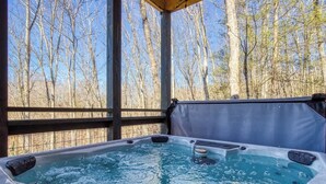A hot tub with a view of leafless trees. - Sassy Bear Hideaway by Beyond Expectations: 4BR w/ Firepit, Game Room & Hot Tub (Sevierville)