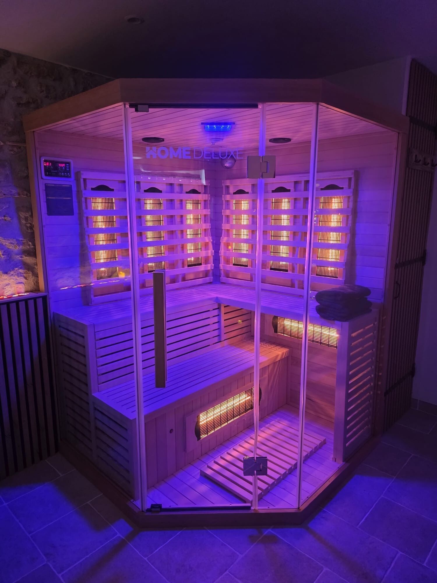 Un sauna doté de plusieurs bancs et d’un panneau de commande.