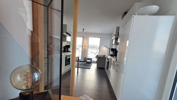 A modern kitchen with white cabinets, a wooden countertop, and a large window. - Spacious Apartment with Exceptional Mountain View, Sauna and Terrace (Winterberg)