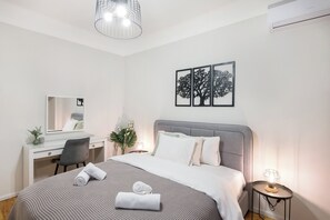 A modern bedroom with a bed, bedside table, lamp, and a desk with a chair. - Porto Sea View Apartments - Kypriou (Thessaloniki)