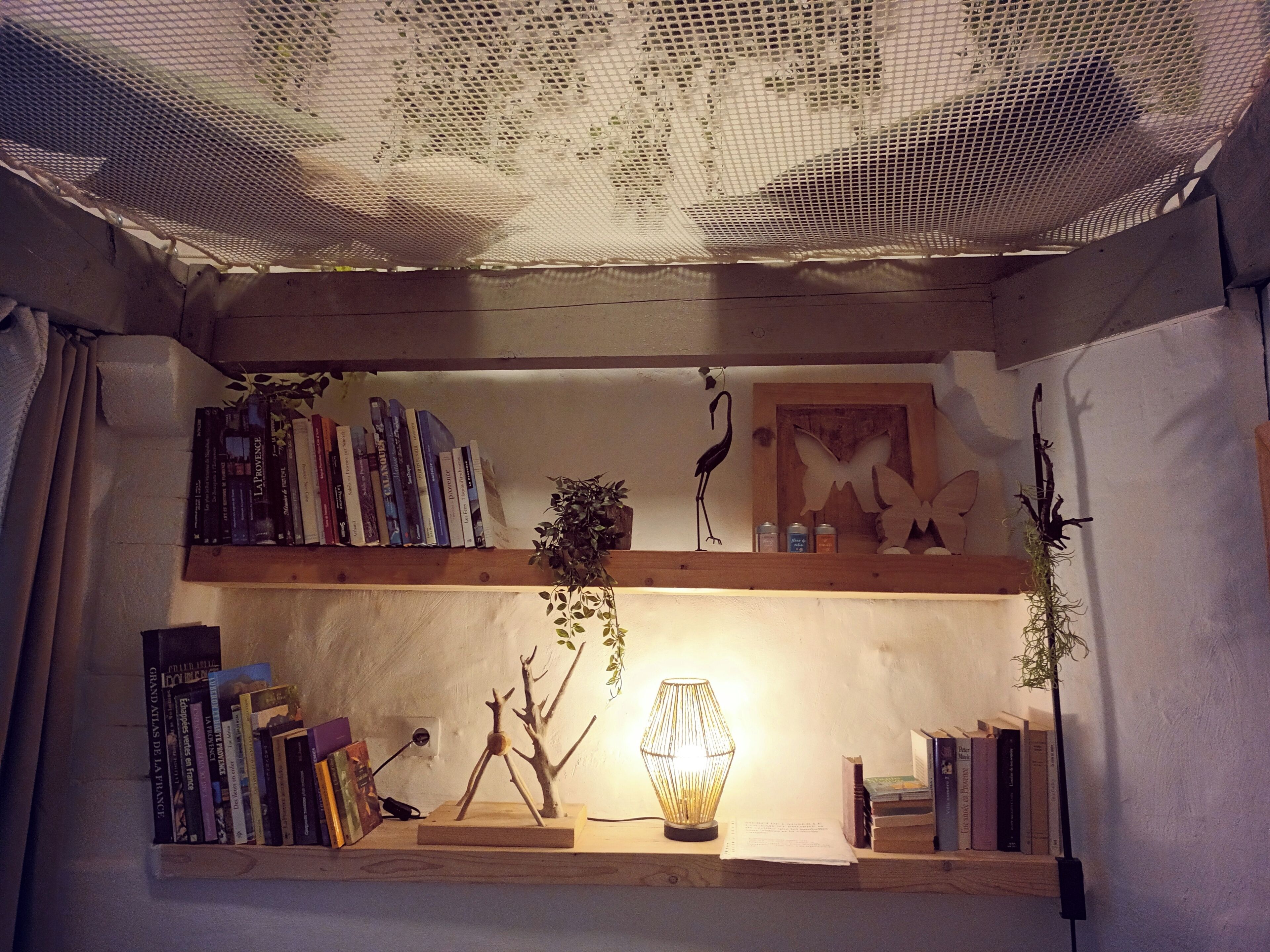 A cozy reading nook with bookshelves, a lamp, and decorative items.