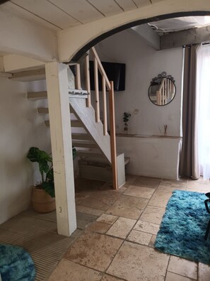 A staircase leading to a landing with a flat ceiling and a wall-mounted mirror.