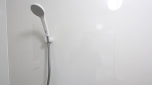 Een douchekop bevestigd aan een witte muur.