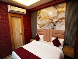 Een hotelkamer met een groot bed, een marmeren hoofdbord en een airconditioning op de muur.