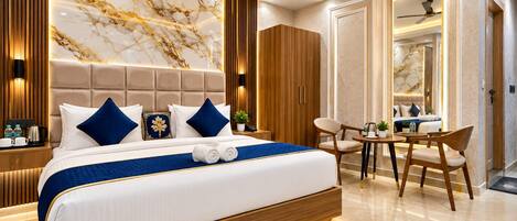 Una habitación de hotel moderna con una cama grande, un área de descanso y un baño.