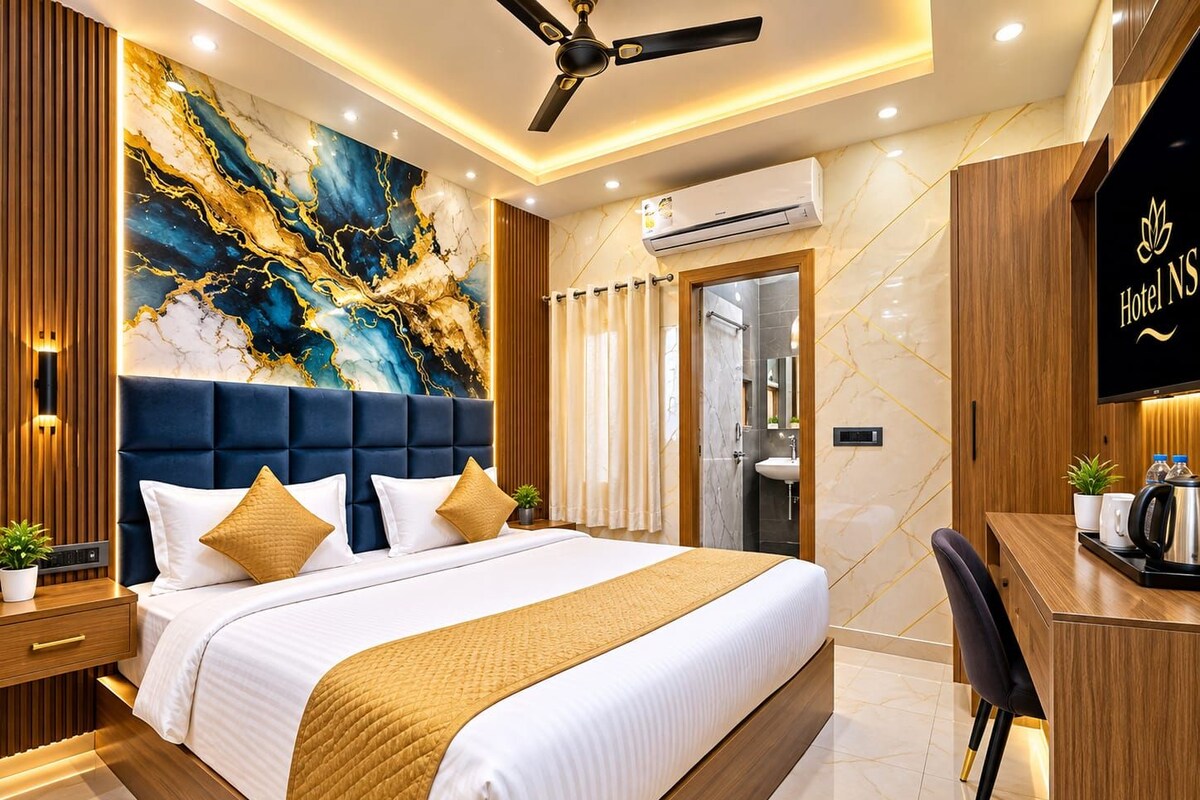 A modern hotel room with a large bed, a desk, and a ceiling fan.