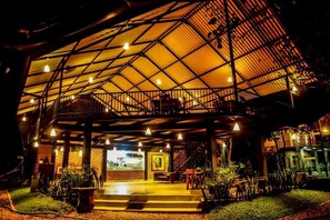 A spacious outdoor area with a covered seating area, a staircase, and a view of the interior. - Doola River Edge (Udawalawa)