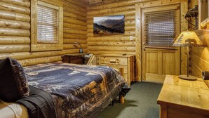 A log cabin bedroom with a bed, a desk, and a window with blinds. - Majestic Bear Retreat, WIFI, Free Attraction ticket, Hot Tub (Pigeon Forge)