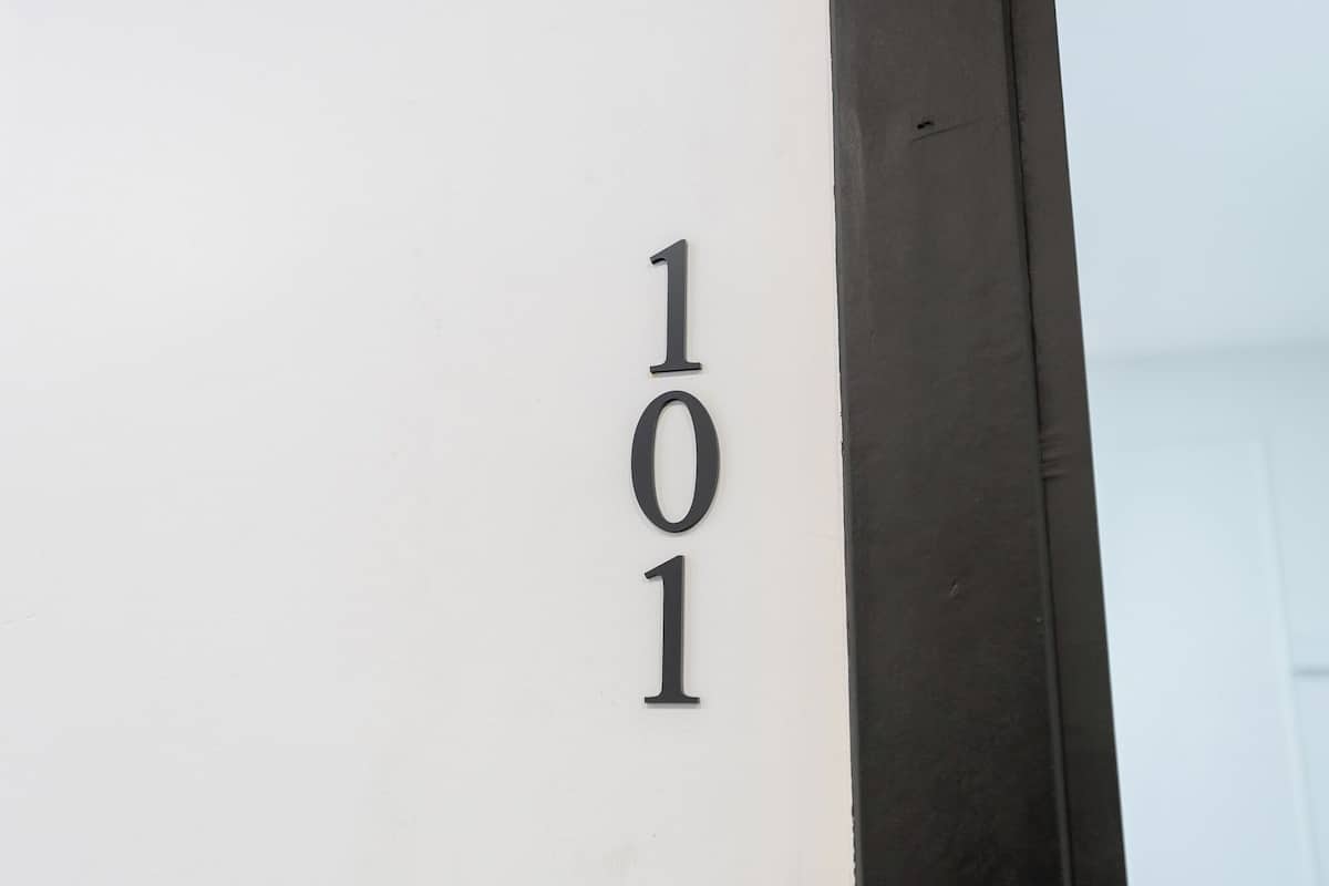A white wall with the number "101" in black, indicating a room number.