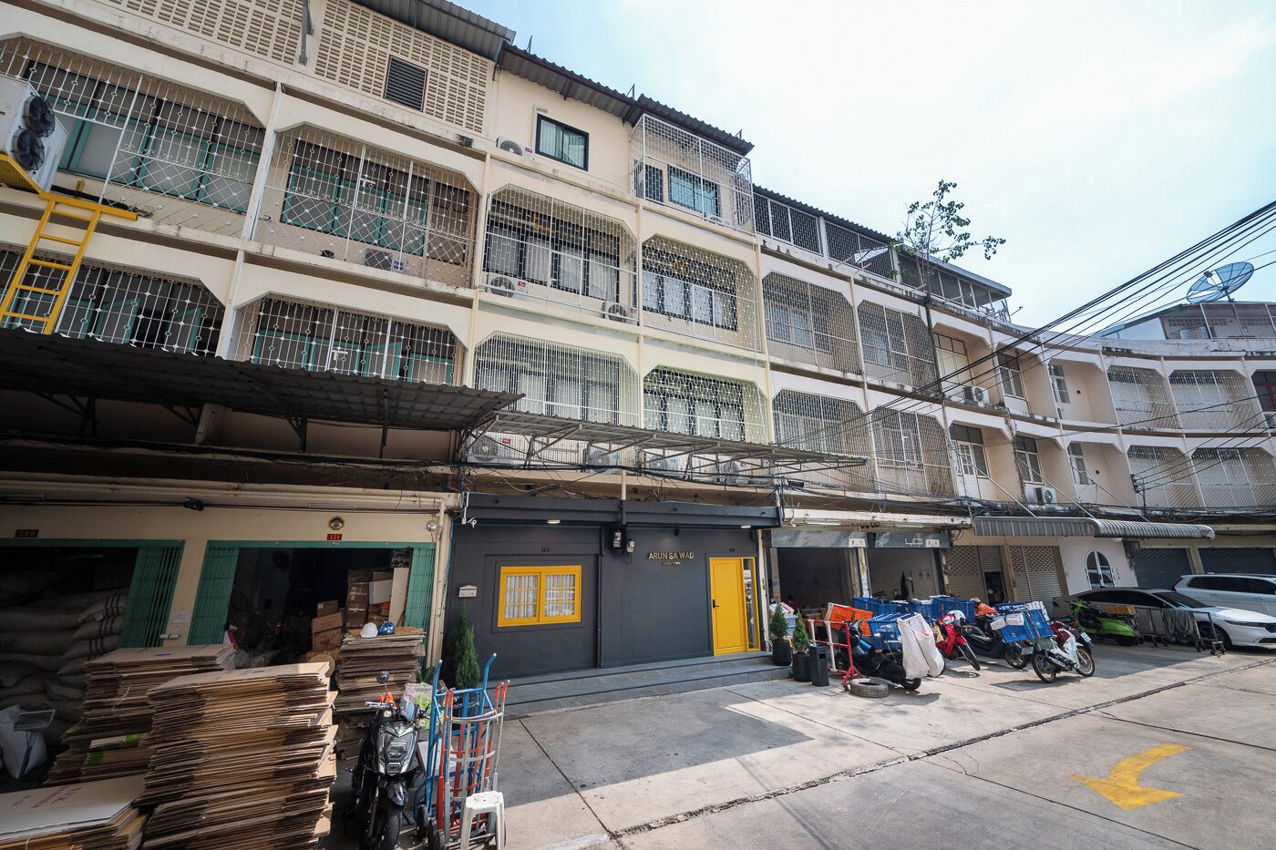 A multi-story building with a ground-level shop and a yellow door.