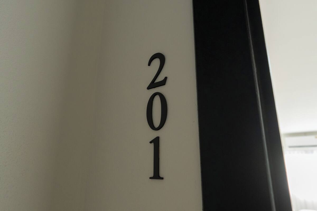 A close-up of a wall with the numbers "201" indicating a room or section number.