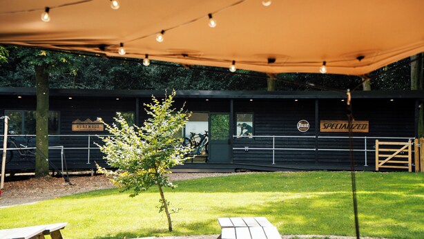 An outdoor seating area with tables and a canopy. - Hurtwood Hideout (Dorking)