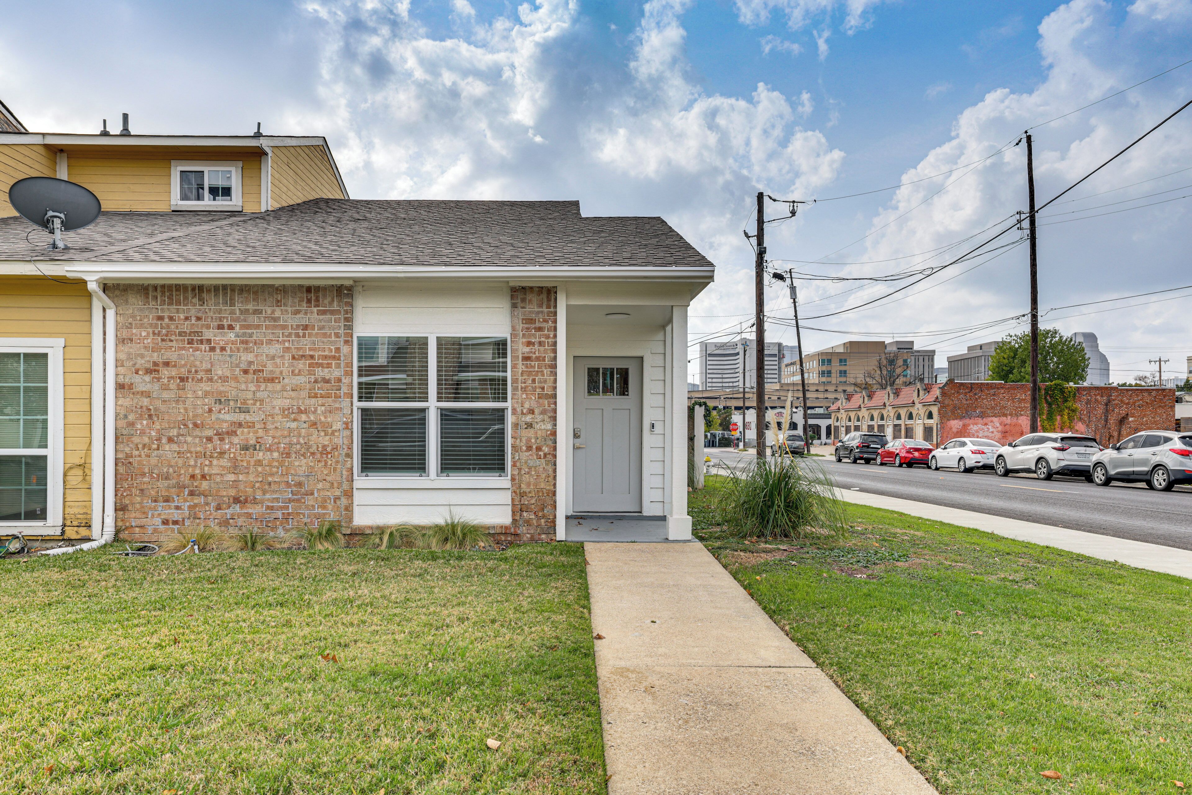 A single-story house with a brick facade, a satellite dish, and a front door.