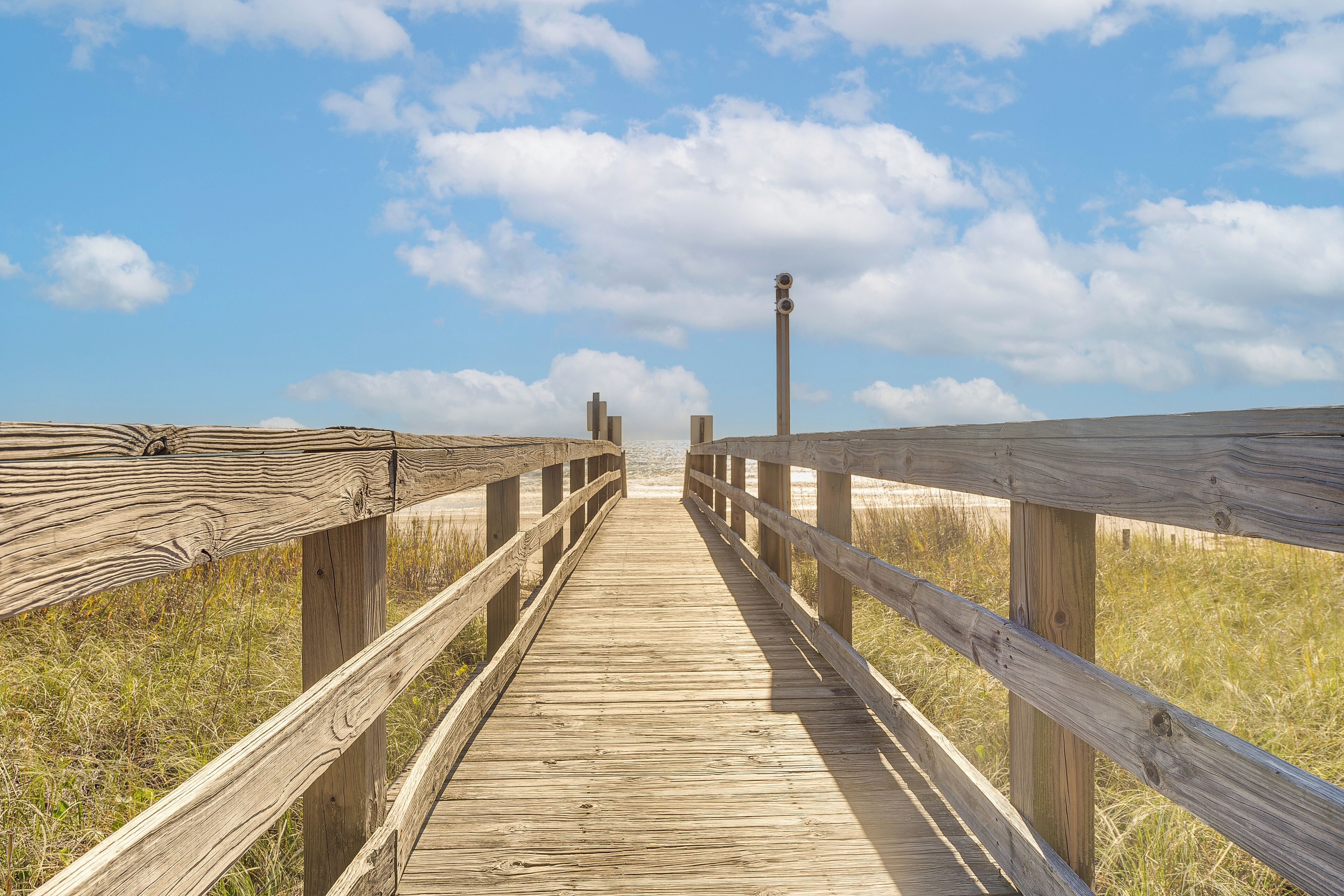 A wooden boardwalk leading to a lighthouse.