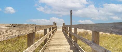 A wooden boardwalk leading to a lighthouse.