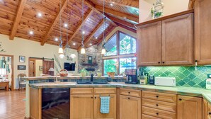 Una cocina amplia con armarios de madera, una isla grande y una chimenea de piedra.