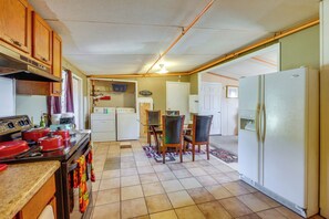 A compact kitchen with wooden cabinets, a stove, and a refrigerator.