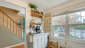 A kitchen with white cabinets, a coffee maker, and a window with a view of the street. - Tranquil Townhouse Retreat w/ Deck in Germantown! (Germantown)