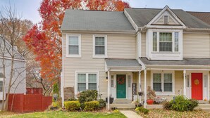A two-story house with a front porch, a red door, and a green door. - Tranquil Townhouse Retreat w/ Deck in Germantown! (Germantown)