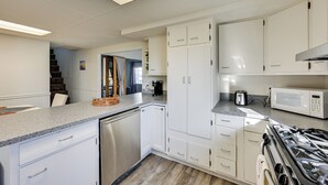 A kitchen with white cabinets, a stainless steel dishwasher, a microwave, and a gas stove. - 3 Mi to Auburn Station! Commuter-friendly Home (Auburn)