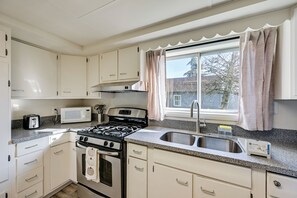 A kitchen with white cabinets, a microwave, a stove, and a sink. - 3 Mi to Auburn Station! Commuter-friendly Home (Auburn)