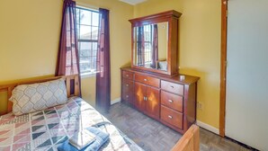 A bedroom with a bed, a wooden dresser, a window with curtains, and a door. - Countryside Escape, 8 Mi to Fvsu & Main Street! (Fort Valley)