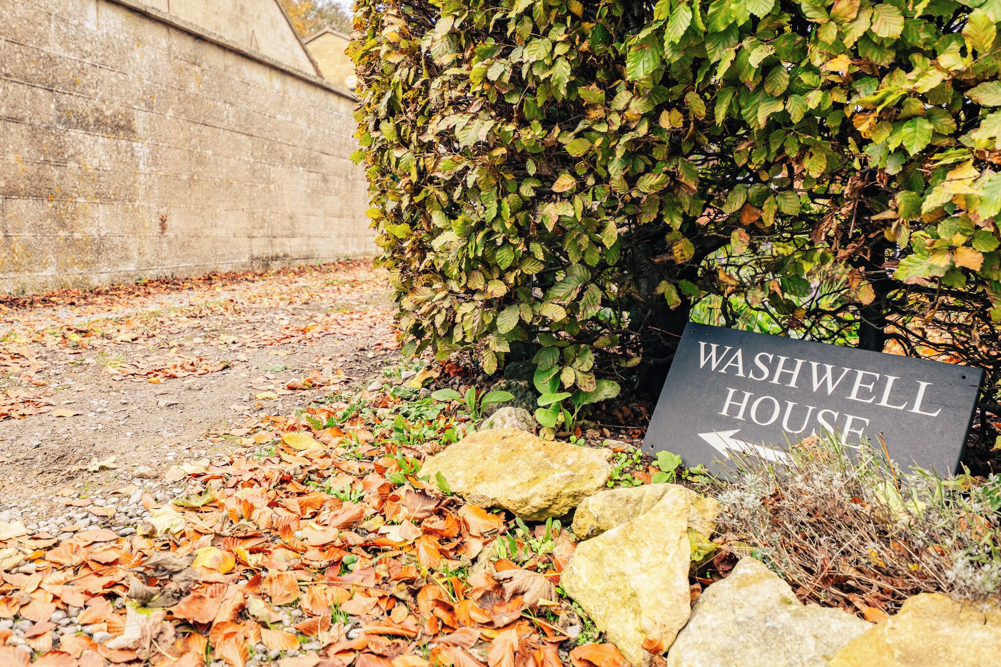 Placa indicando Washwell House, com uma seta apontando para a esquerda.