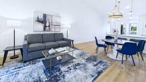 A modern living room with a sofa, coffee table, and dining area. - Golf, Dining, and Convenience Awaits  🚀 (Titusville)