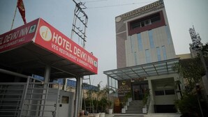 A hotel entrance with a sign for Hotel Devki Inn, a banquet hall, and a modern building with a glass facade. - Hotel Devki Inn (Gorakhpur)