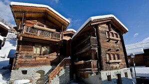 A wooden chalet with a stone foundation, wooden balconies, and a snow-covered roof. - 4-room chalet for 6 people in the heart of the old village of Grimentz: 1 bedroom with double bed an (Grimentz)
