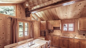 A wooden cabin interior with a dining area, kitchen, and large windows. - 4-room chalet for 6 people in the heart of the old village of Grimentz: 1 bedroom with double bed an (Grimentz)