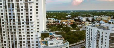 A high-rise hotel with multiple floors, a rooftop pool area, and a view of the surrounding cityscape.