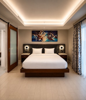 A modern hotel room with a large bed, a ceiling light, a wall-mounted artwork, and a window with curtains. - CIRC Hotel By Hosteeva (Hollywood)