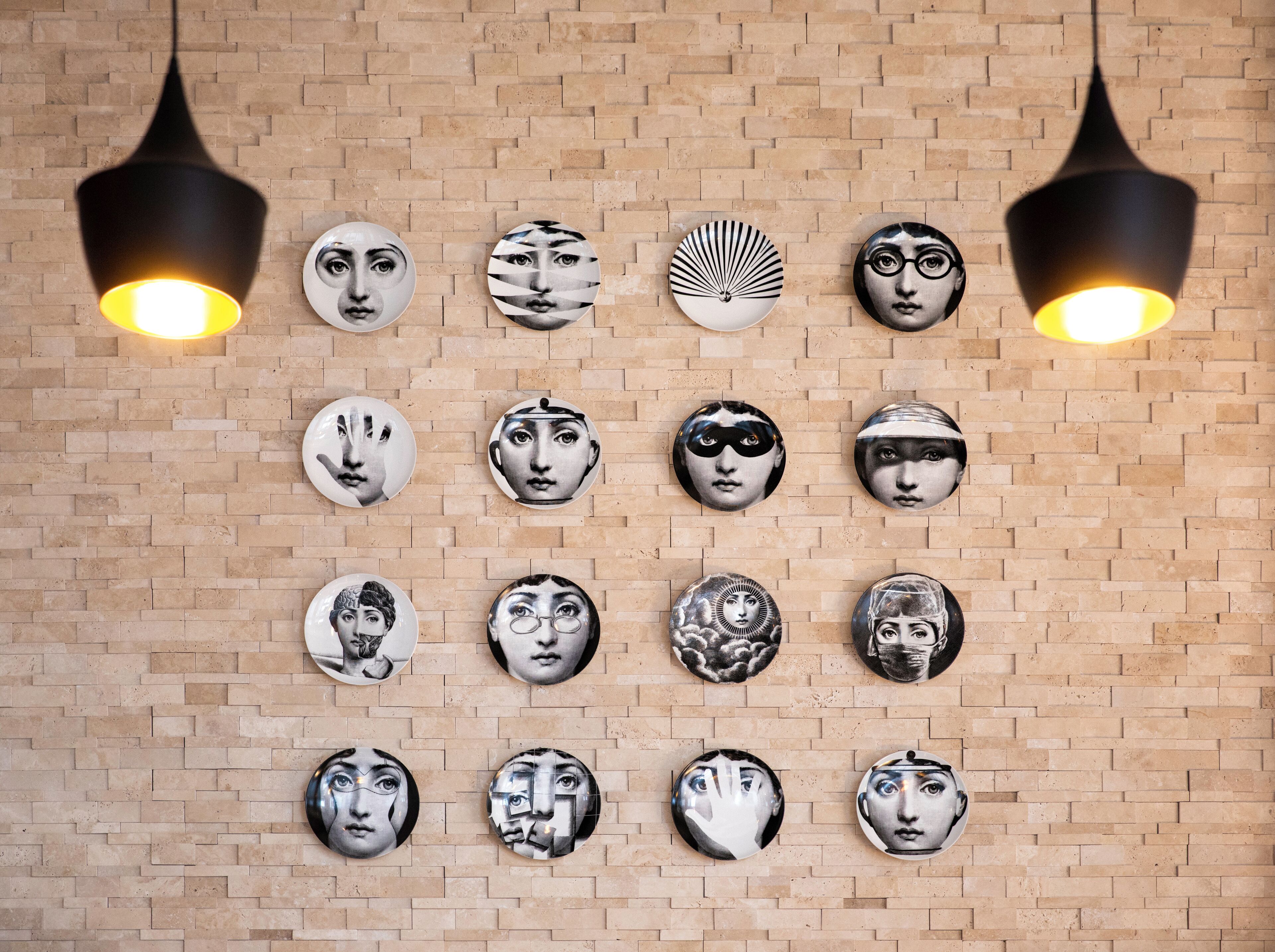 A wall with circular artwork arranged in a grid pattern.