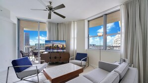 A modern hotel room with a large window, a flat-screen TV, a sofa, a coffee table, and a ceiling fan. - CIRC Hotel By Hosteeva (Hollywood)