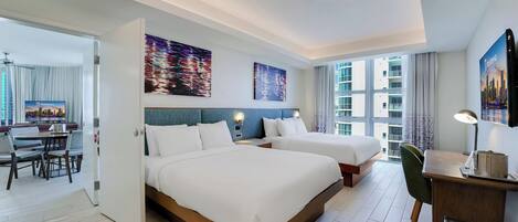 A modern hotel room with two beds, a desk, and a dining area.